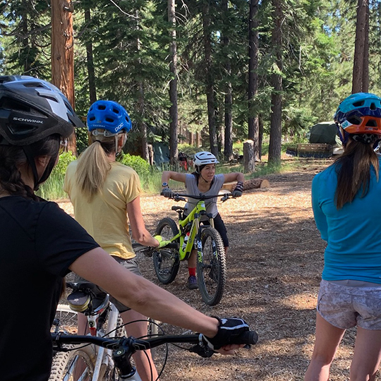 Women observing instructor at mountain bike clinic